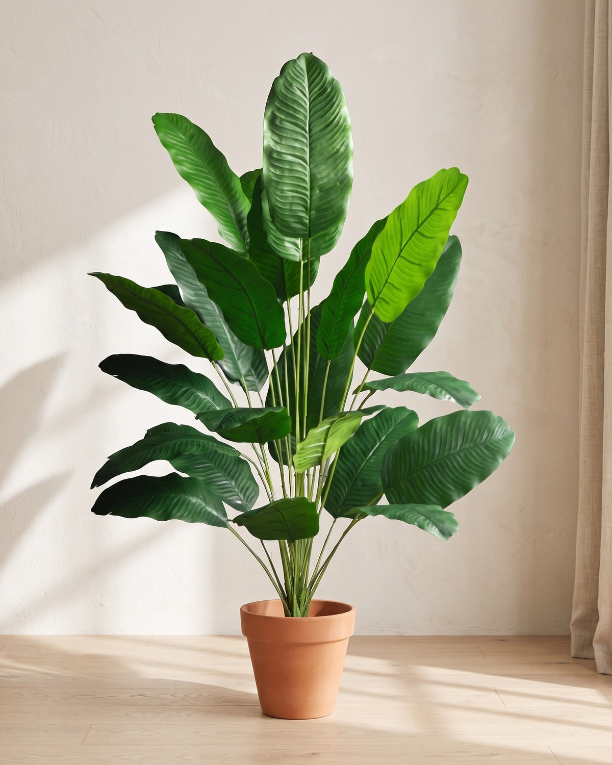 Green leaf artificial banana leaf plant, 46.9 in with eighteen leaves, in a plain terracotta pot on pale oak floorboards; pot not included