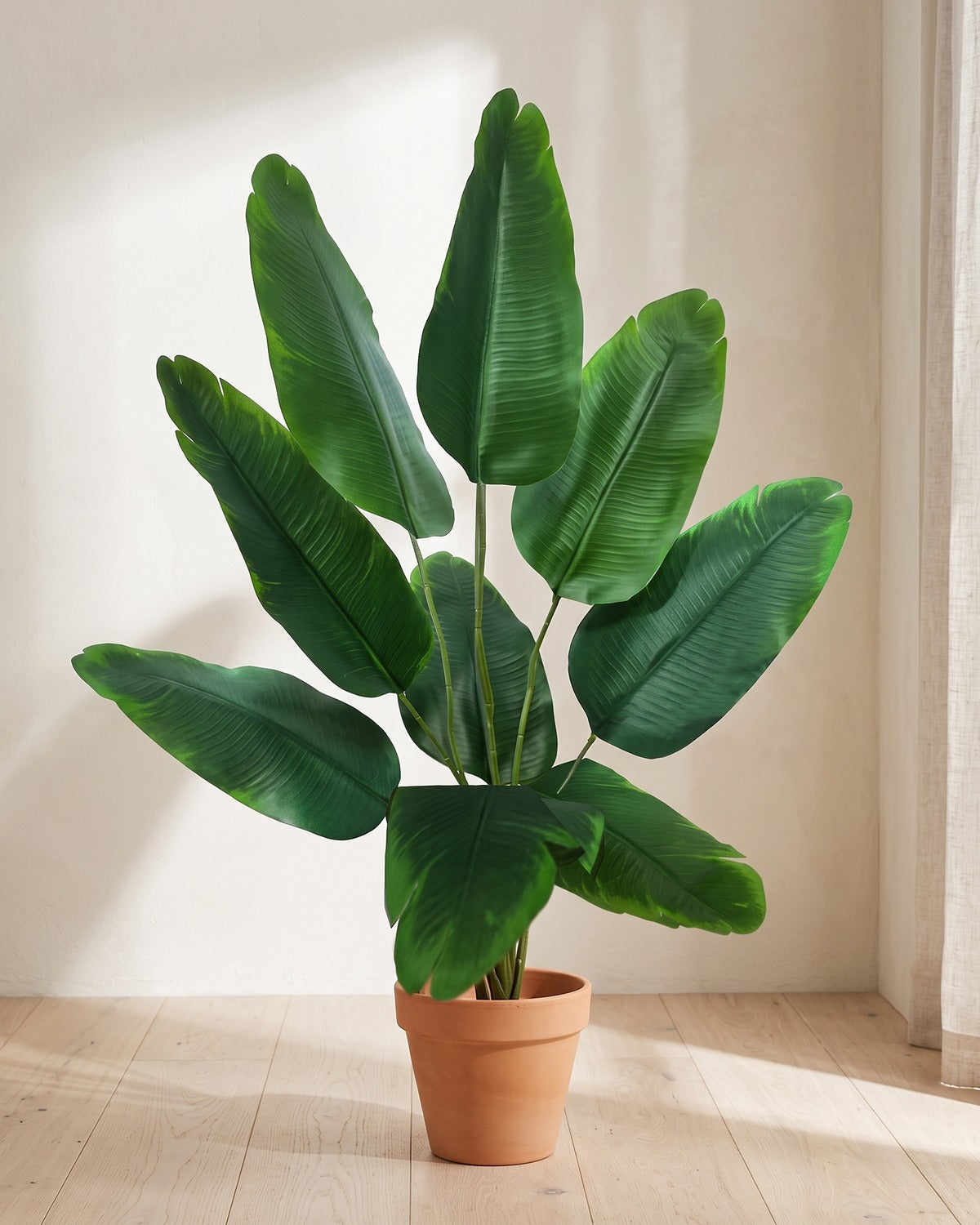 Green leaf artificial banana leaf plant, 33.9 in with nine leaves, in a plain terracotta pot on pale oak floorboards; pot not included