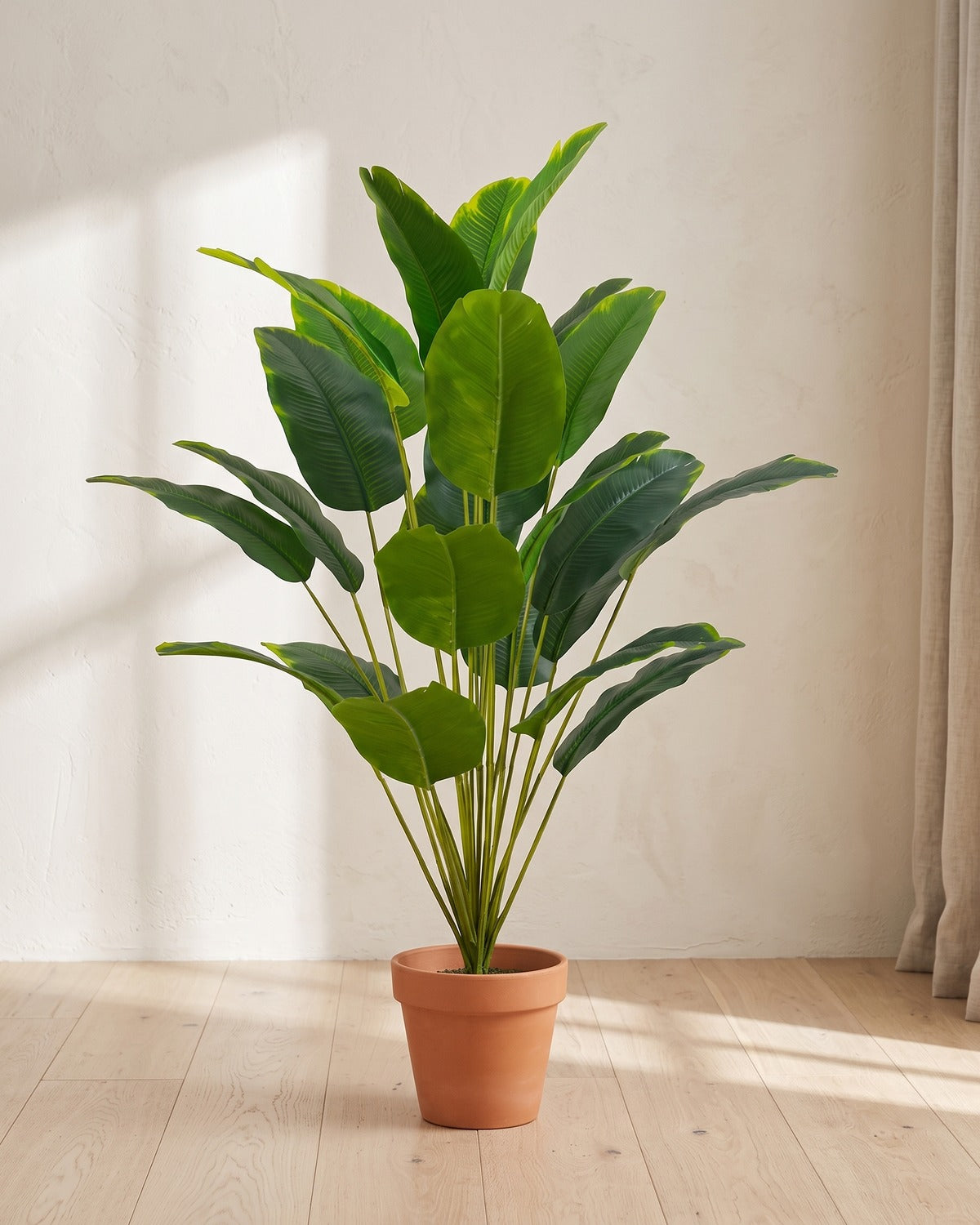 Green leaf artificial banana leaf plant, 35.4 in with twenty-four leaves, in a plain terracotta pot on pale oak floorboards; pot not included