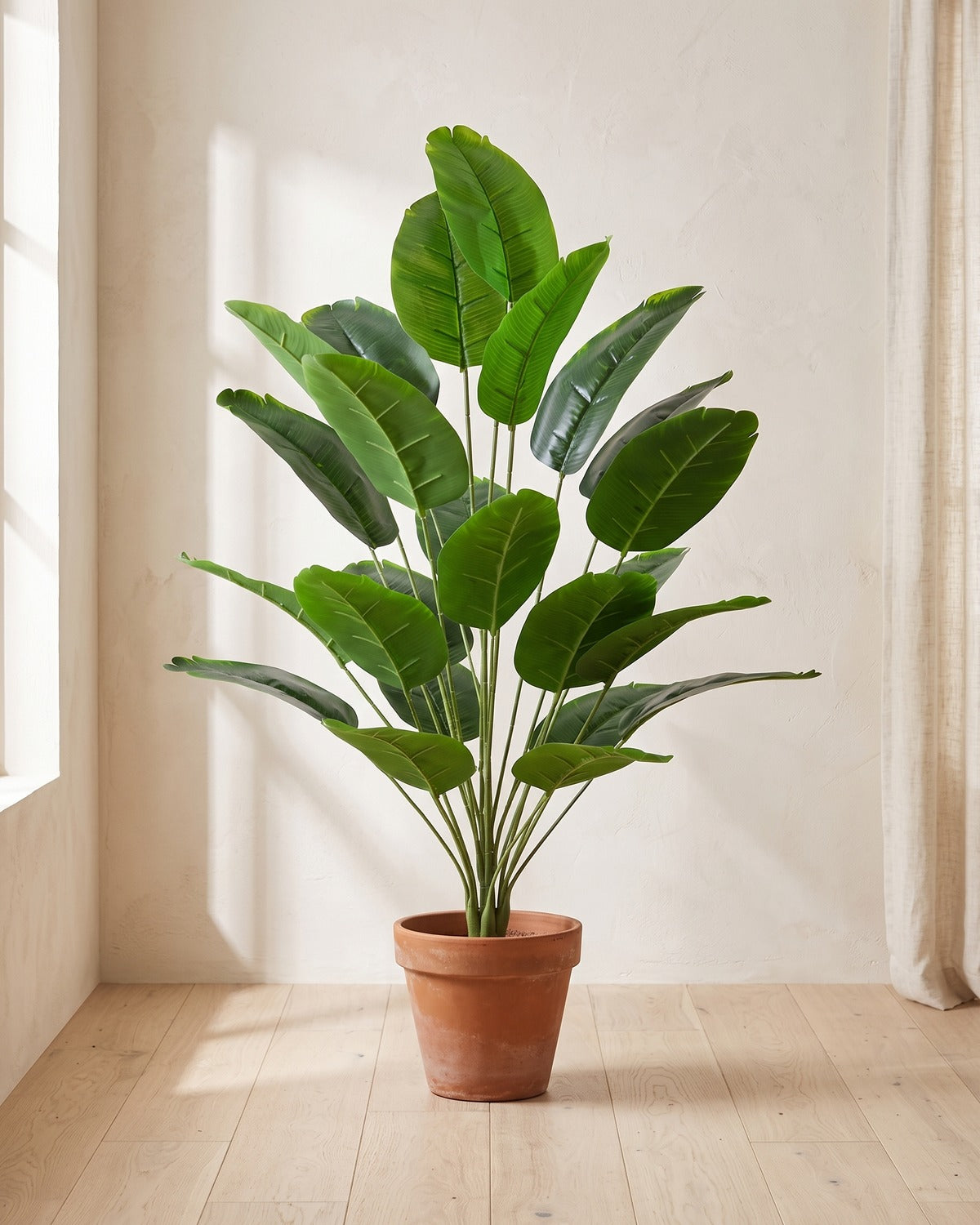 Green leaf artificial banana leaf plant, 41.3 in with twenty-four leaves, in a plain terracotta pot on pale oak floorboards; pot not included