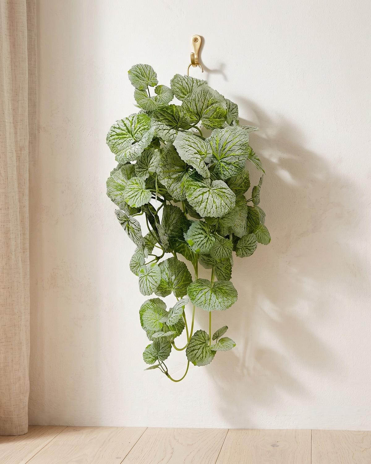 Artificial hanging begonia vine at 15.7 in, hanging from a small hook on a warm plaster wall; hook not included