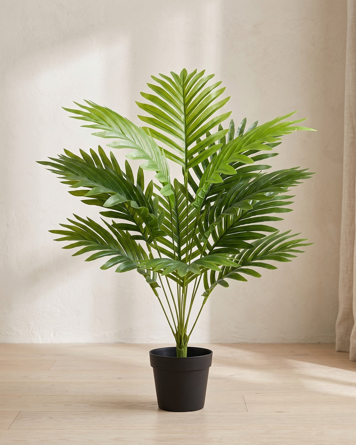 An artificial palm leaf bush with twelve fronds, 23.6 in tall, in a plain black nursery pot on pale oak floorboards; pot not included