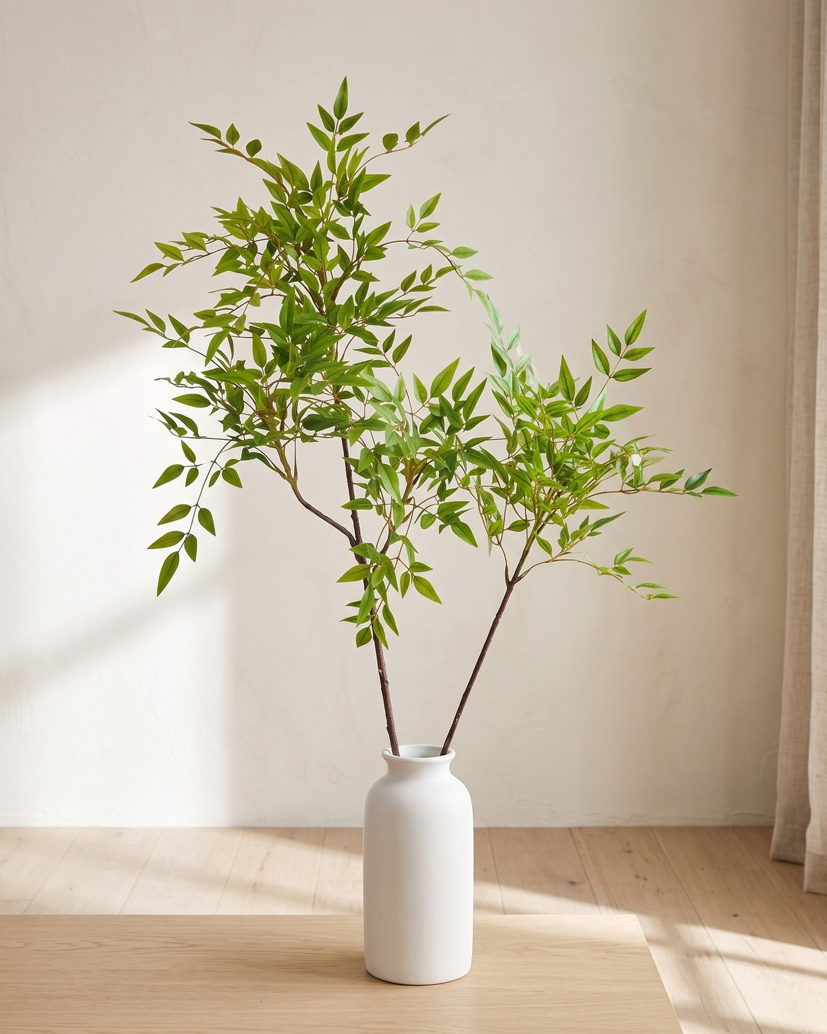 Fine leaf artificial tree branch, set of 2, 45.3 in, standing in a plain white vase on a pale oak table; no vase is included