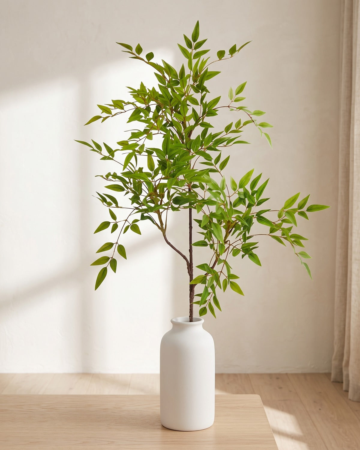Fine leaf artificial tree branch, 3 stems, 45.3 in, standing in a plain white vase on a pale oak table; no vase is included