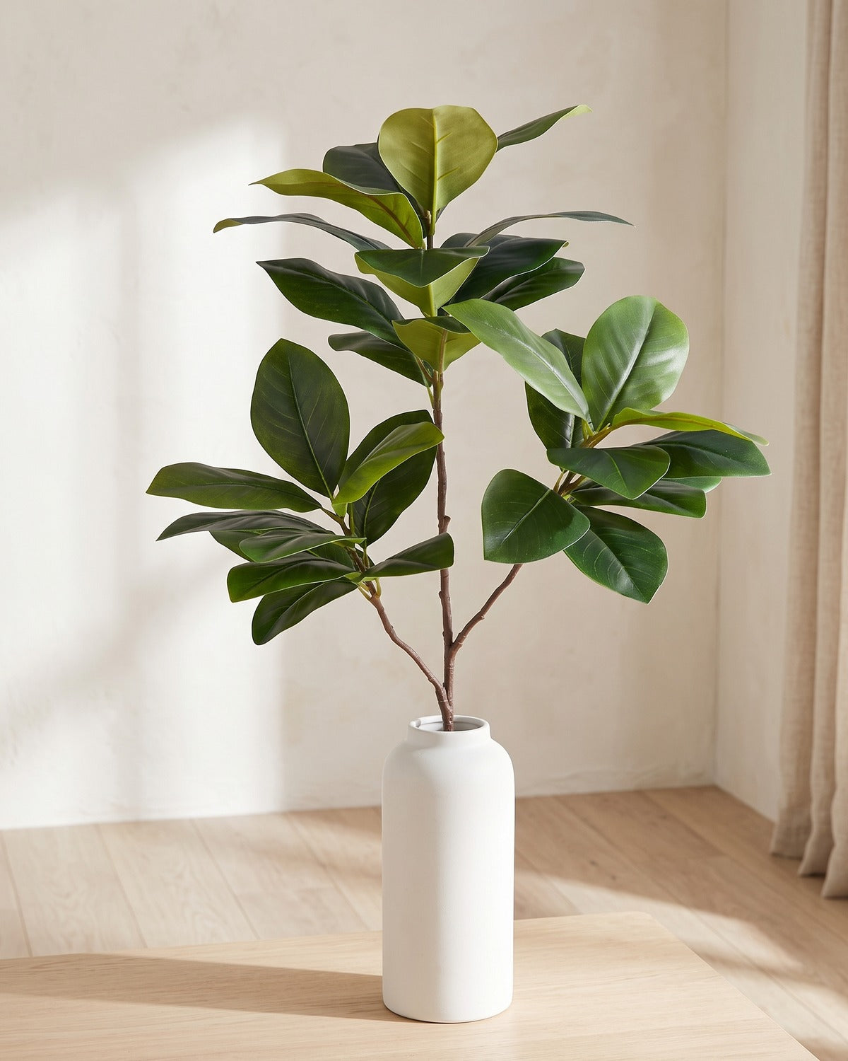 Glossy oval leaf artificial tree branch, 3 stems, 53.1 in, standing in a plain white vase on a pale oak table; no vase is included