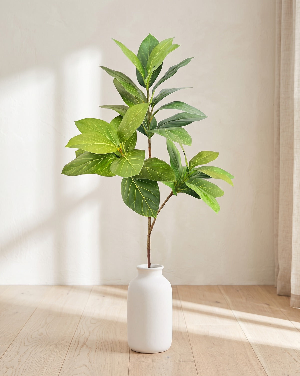 Veined oval leaf artificial tree branch, 3 stems, 53.1 in, standing in a plain white vase on a pale oak table; no vase is included
