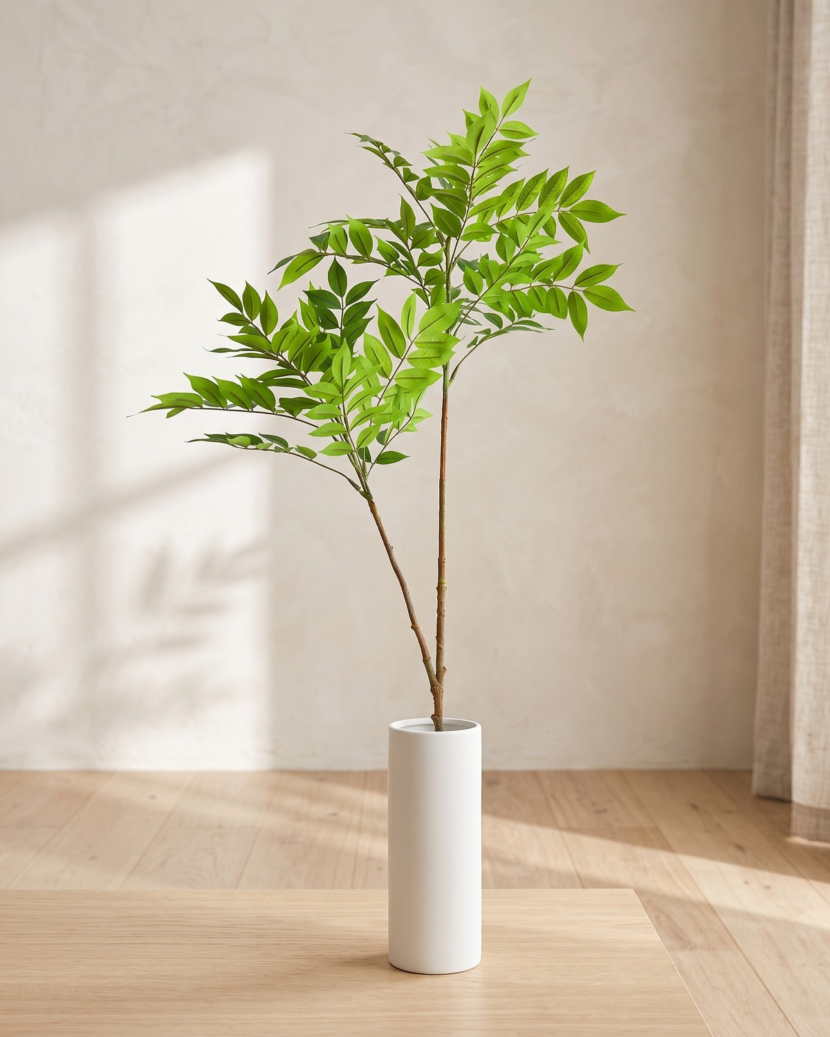Feather leaf artificial tree branch, 2 stems, 43.3 in, standing in a plain white vase on a pale oak table; no vase is included