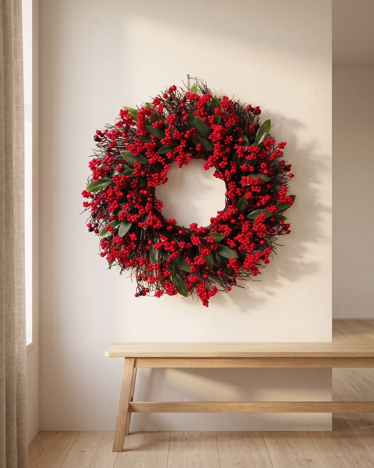 Berry and twig Christmas wreath hanging on a plaster wall above a bench
